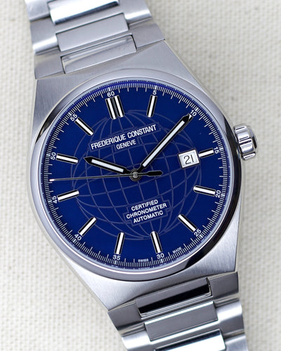 Frederique constant steel watch with world map engraved on blue dial.