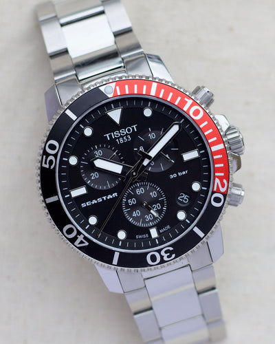 Tissot watch with black dial and red bezel insert 