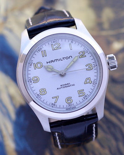Hamilton watch with black leather strap on a blurred background