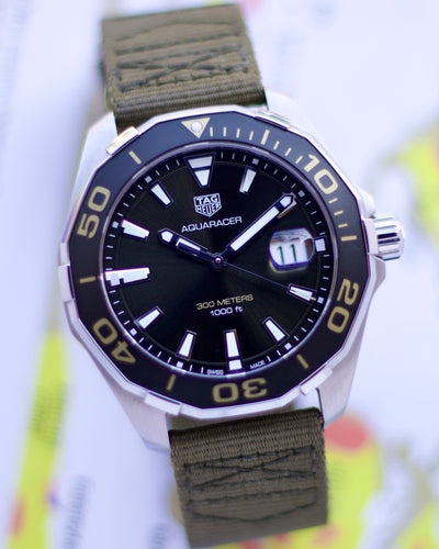 Tag Heuer Aquaracer watch with green strap on a blurred background