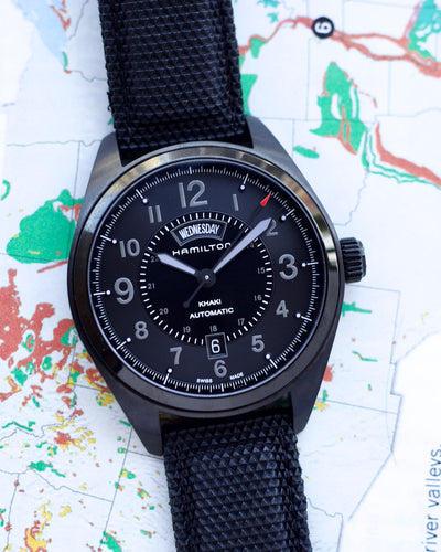 Hamilton watch with black strap on a map background
