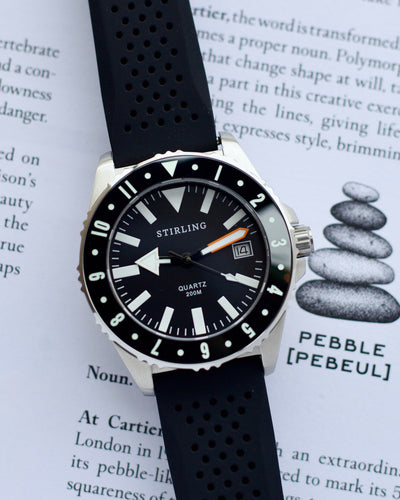 Stirling watch with black strap on a book page