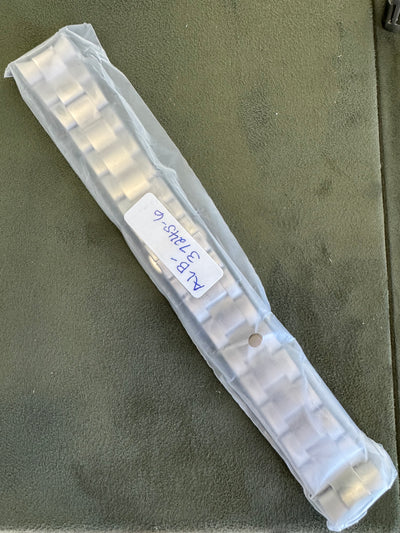 Clear plastic strip with small white components on a green surface