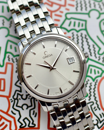 Silver Omega watch on a colorful abstract background