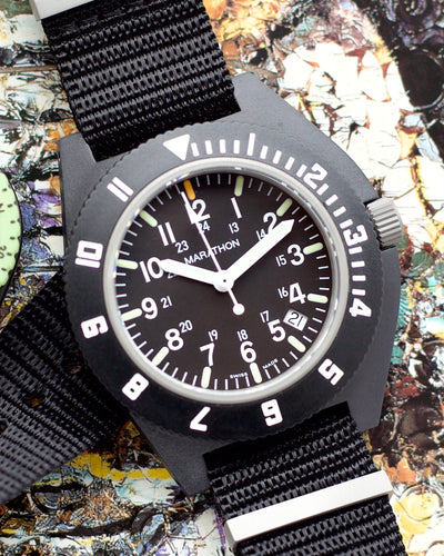 Black wristwatch with a textured strap on a colorful background