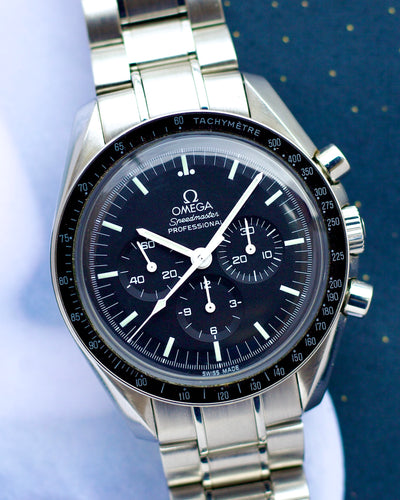 Silver Omega watch with black dial on a light blue background