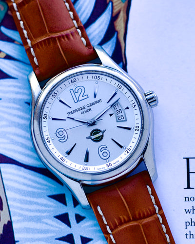 Watch with brown leather strap on a patterned surface