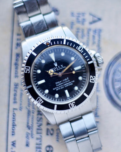 Rolex Steel watch with a black dial on a newspaper background