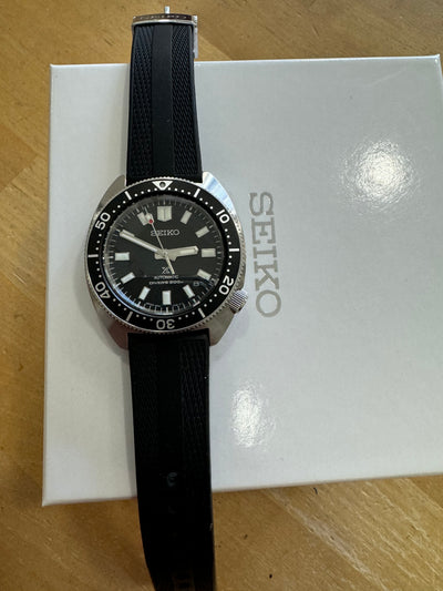 Seiko steel diver watch on a white box