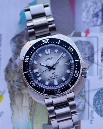 Seiko watch with a silver bracelet on a map background