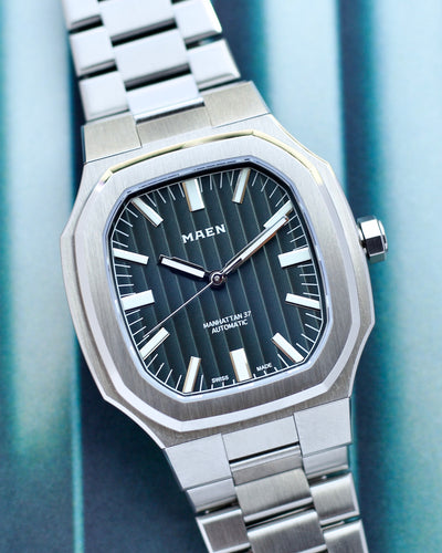 Silver watch with a blue face on a blue striped background