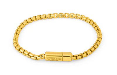 Gold chain bracelet with a cylindrical clasp on a white background