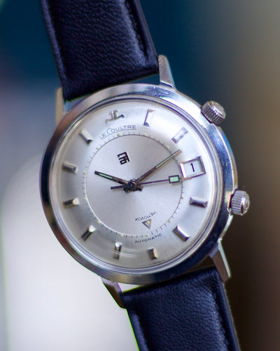 Wristwatch with blue strap and silver case on a blurred background