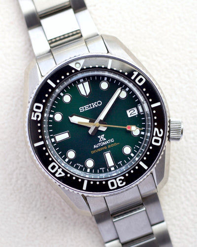 Seiko steel watch on green dial
