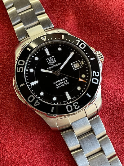 steel wristwatch on black dial and steel bracelet  