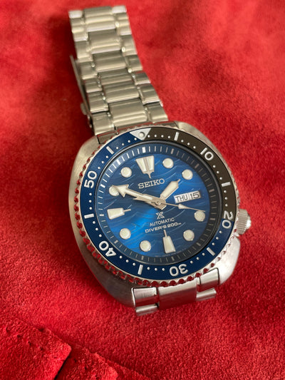 steel watch with blue wavy dial