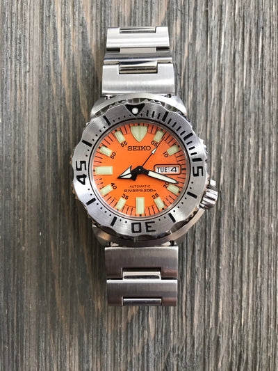 wrist watch steel case orange dial steel bracelet