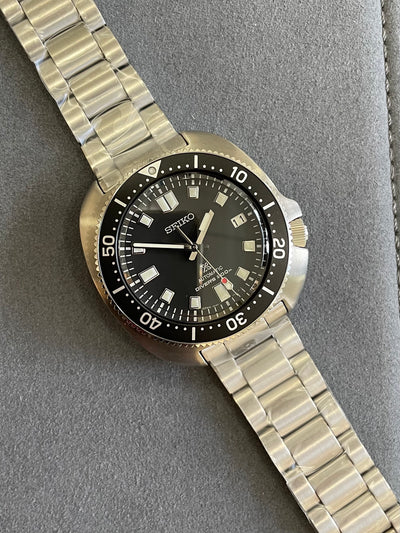 steel wristwatch on black dial and steel bracelet