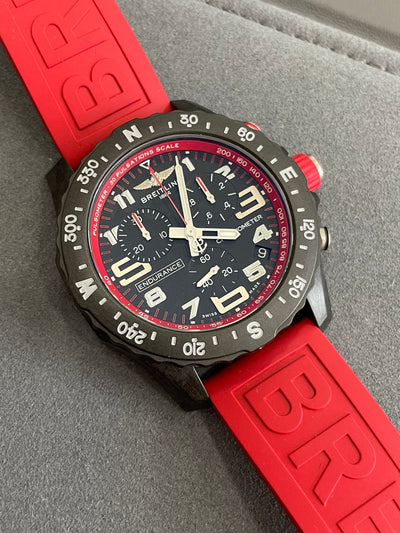 composite wristwatch stopwatch style on black dial and red rubber band
