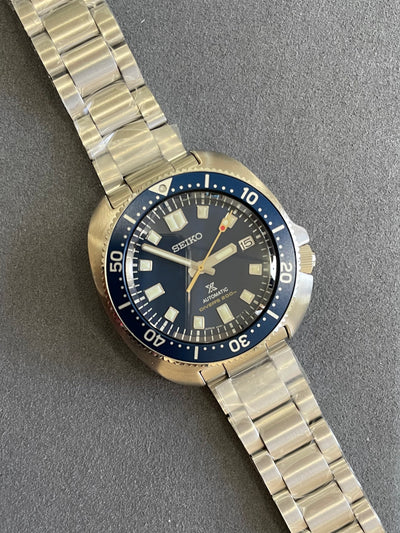 steel wristwatch on blue dial and steel bracelet