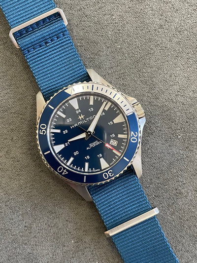 steel wristwatch on blue dial and blue band