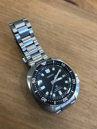 Steel wrist watch with black dial on steel bracelet
