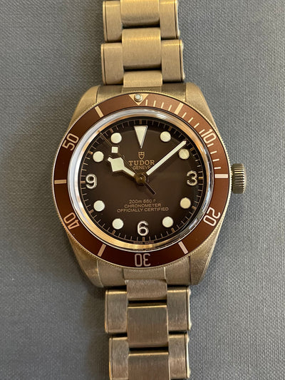 bronze wristwatch on brown dial and bronze bracelet