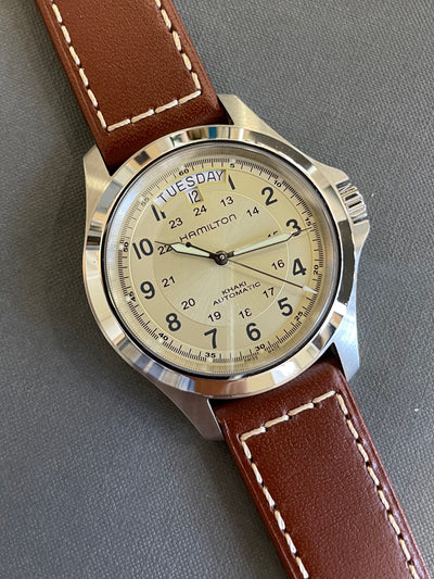 steel wristwatch on champagne dial and brown band