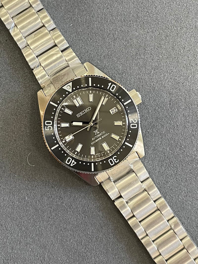steel wristwatch on gray dial and steel bracelet