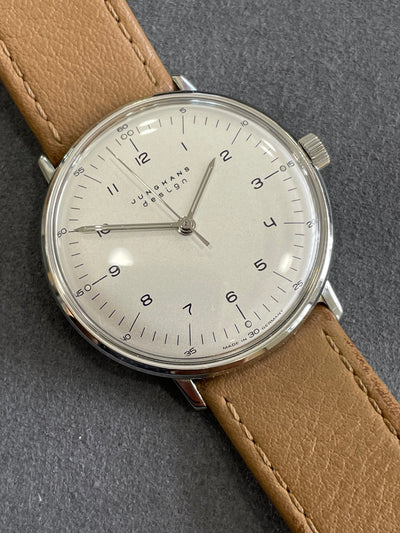 steel wristwatch on silver dial and tan leather band